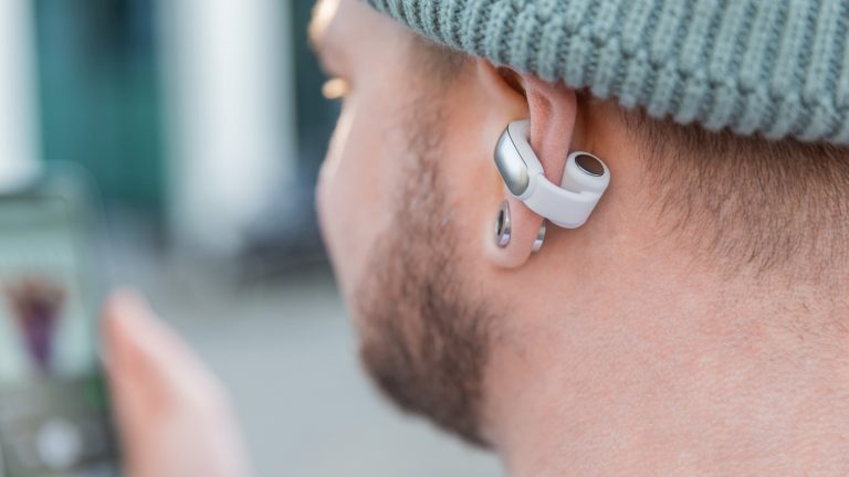 Bose Ultra Open Earbuds Nahaufnahme einer Person, die die Bose Ultra Open Earbuds trägt.