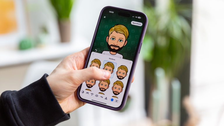 Eine Person hält ein iPhone in der Hand, auf der die Bitmoji-Erstellung zu sehen ist.
