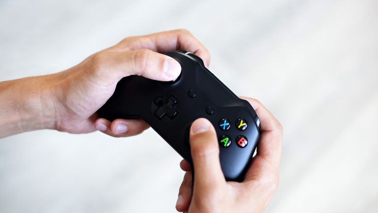 Eine Person hält den Controller einer Xbox Series in der Hand.
