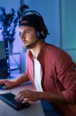 Eine Person mit einem Headset auf dem Kopf sitzt vor einem Game-Streaming-Setup.