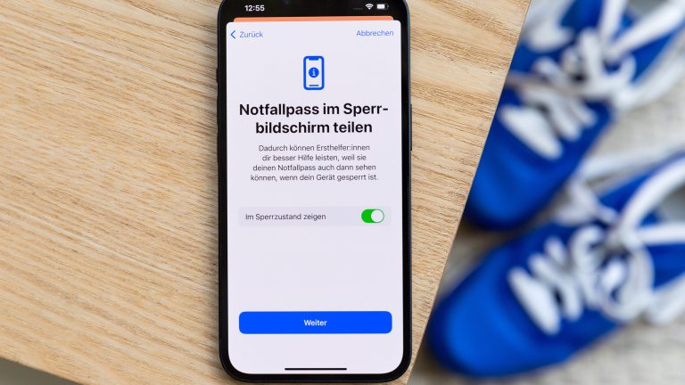 Apple Health richtig nutzen: Gesund leben mit der App Auf einem Holztisch liegt ein iPhone. Darauf ist die Option zu sehen, den Notfallpass im Sperrzustand Отзывы zu lassen.