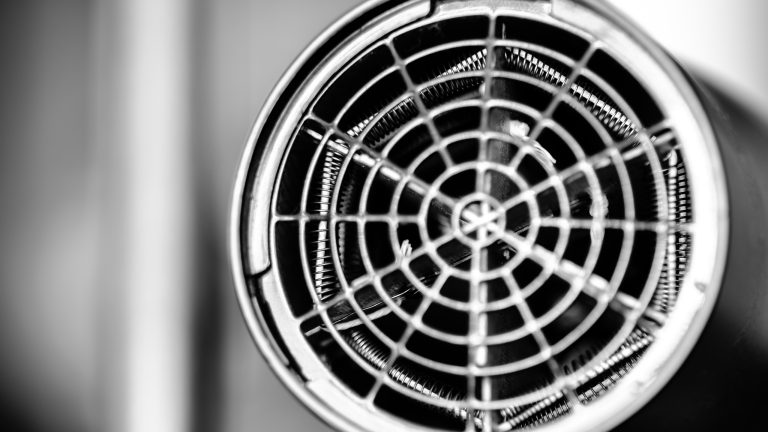 Föhn überhitzt und schaltet sich aus? Das kann der Grund sein Die runde Ausblasöffnung eines regulären Föhns mit abschraubbaren Gitter.