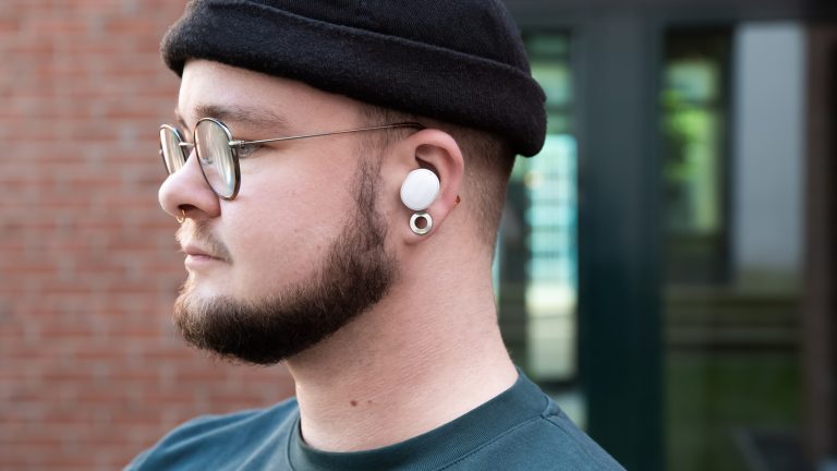Eine Person trägt einen weißen In-Ear-Kopfhörer von Fairphone.