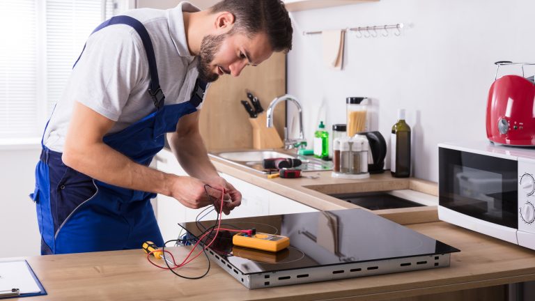 Elektroherd anschließen lassen Eine Person überprüft den Strom an einer Herdplatte.