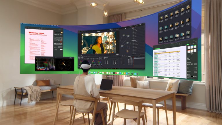 Eine Person sitzt in ihrem Wohnzimmer und hat eine Apple Vision Pro Brille auf. Vor ihr schwebt ein Ultra Wide Screen mit mehreren offenen Apple Apps.