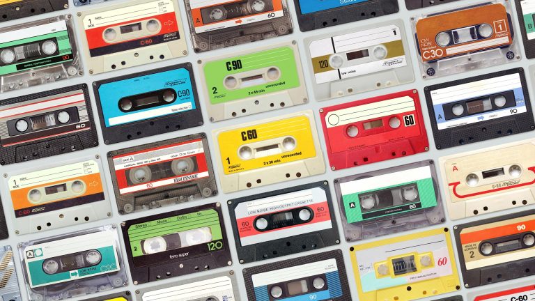 Kassetten digitalisieren Viele verschiedenfarbige Musikkassetten nebeneinander.