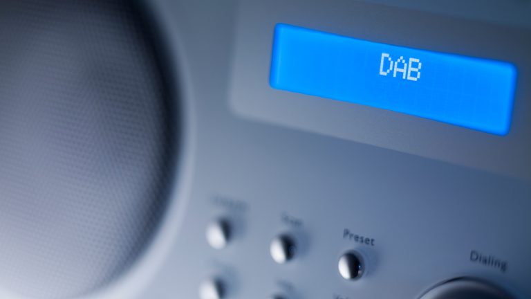 Radioempfang verbessern Ein kleiner blau leuchtender Bildschirm eines Digitalradios, auf dem DAB steht.
