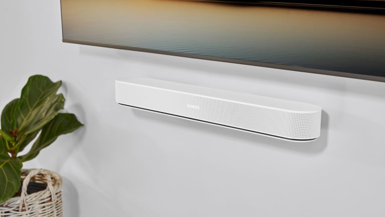 Soundbar anschliessen, Soundbar richtig einstellen, Sonos beam gen2 Eine Soundbar hängt unter einem TV-Bildschirm an der Wand neben einer Pflanze.