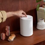 Eine Person hält ihren Finger oben auf das Bedienfeld eines Sonos-Lautsprechers.