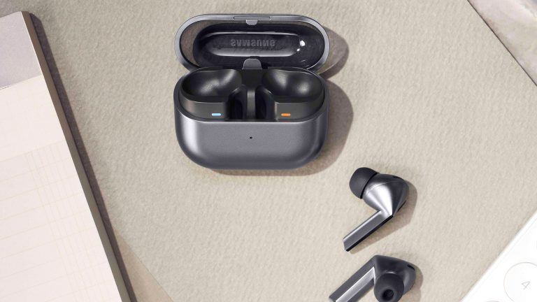 Samsung News Die Galaxy Buds3 Pro liegen neben ihrem Ladecase auf einem Tisch.