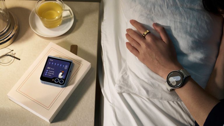 Samsung News Eine Person liegt im Bett und trägt an einer Hand einen Galaxy Ring und eine Galaxy Watch7. Neben ihr liegt ein Z Flip6.