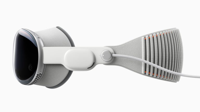 Apple Vision Pro, So richtest du das Headset ein Seitenansicht einer Apple Vision Pro, bei der das Ladekabel angebracht ist.