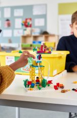 LEGO Spike, Nachfolger von Mindstorms im Überblick Zwei Kinder spielen an einem Tisch mit LEGO Spike. Eines davon bedient dabei ein Tablet.