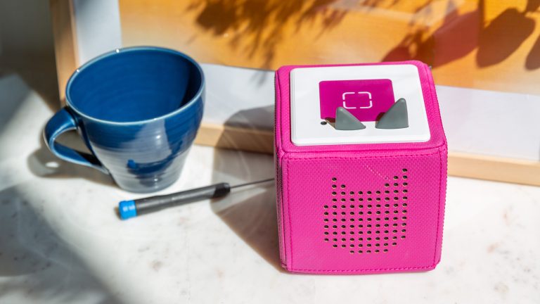 Eine Toniebox ein Schraubendreher und eine Tasse stehen nebeneinander auf einer Marmor-Oberfläche.