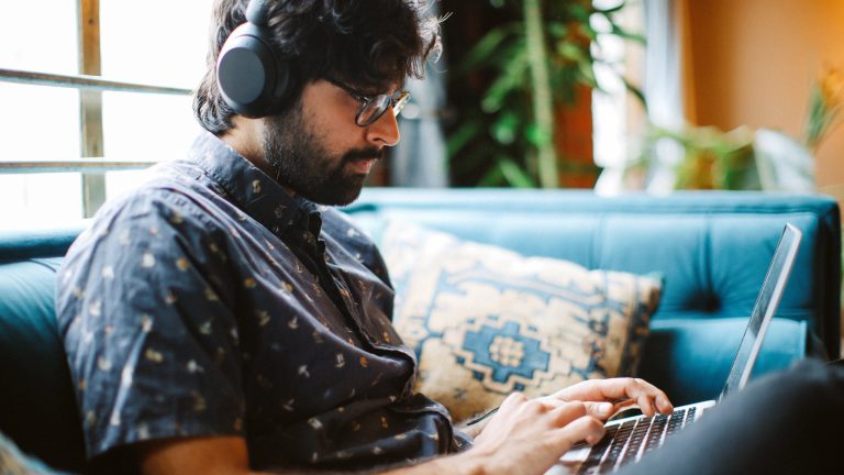iCloud-Musikmediathek, Aktivieren, nutzen und deaktivieren Eine Person mit Kopfhörern sitzt vor einem MacBook Pro.