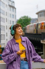 Eine Person ist in Hamburg unterwegs und hört dabei per Smartphone und Kopfhörer Musik.