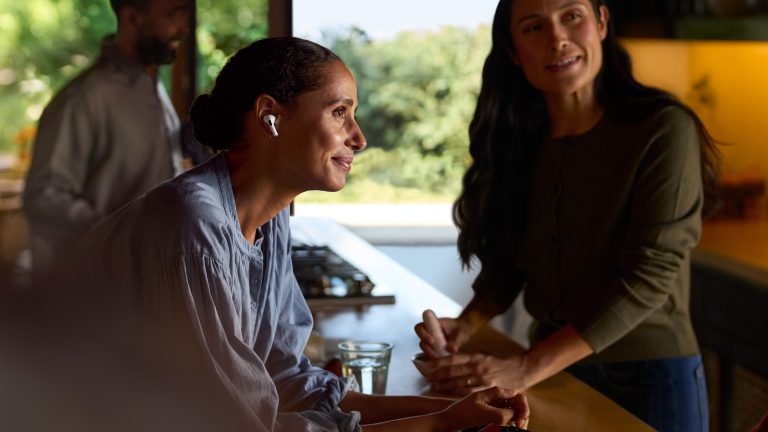 AirPods 2024, Die neue Audio-Generation Eine Person unterhält sich in der Küche mit einer anderen Person und trägt AirPods Pro 2.