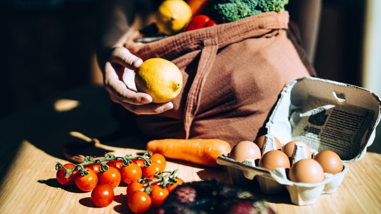 Foodwaste, So vermeidest du es, Lebensmittel wegzuschmeißen Obst, Gemüse und Eier werden aus einer Einkaufstüte geräumt.
