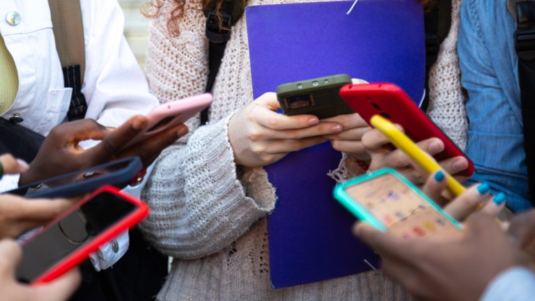 Handyhülle reinigen, Ein Leitfaden zur effektiven Pflege Mehrere Personen halten ihre Smartphones in unterschiedlichen Schutzhüllen nebeneinander.