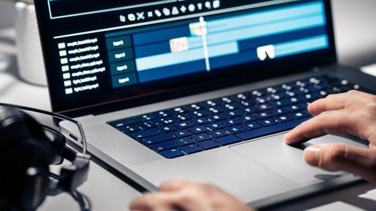 Videos schneiden, Tipps und Anleitungen für dein Video Eine Person sitzt an einem Mac und bearbeitet ein Video.