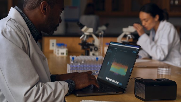 iPad Pro vs. MacBook Pro 2024, Die Geräte im Specs-Vergleich Eine Person in einem Kittel sitzt mit einem MacBook Pro in einem Labor.