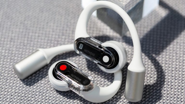 Nothing Ear (open), Stilvolles Design und innovative Technologie Zwei Nothing Ear (open) Buds liegen auf einem Untergrund aus Stoff. Die beiden Touchflächen sind nebeinander ausgerichtet.