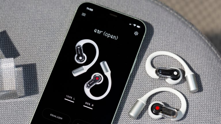 Nothing Ear (open), Stilvolles Design und innovative Technologie Zwei Nothing Ear (open) liegen neben einem Smartphone, auf dem die Nothing X App geöffnet ist.
