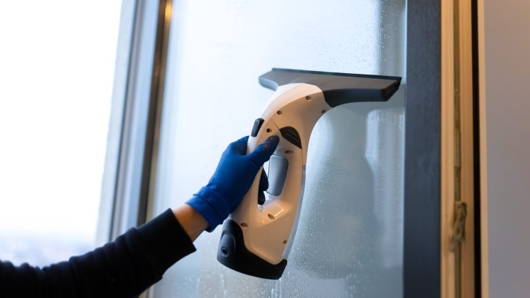 Fenstersauger, 6 Geräte für streifenfreie Sauberkeit Eine Person zieht mit einem Fenstersauger ein geöffnetes Fenster ab.