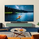 Produktbild von einem LG C4, der auf einer kleinen TV-Bank in einem Wohnzimmer steht.)