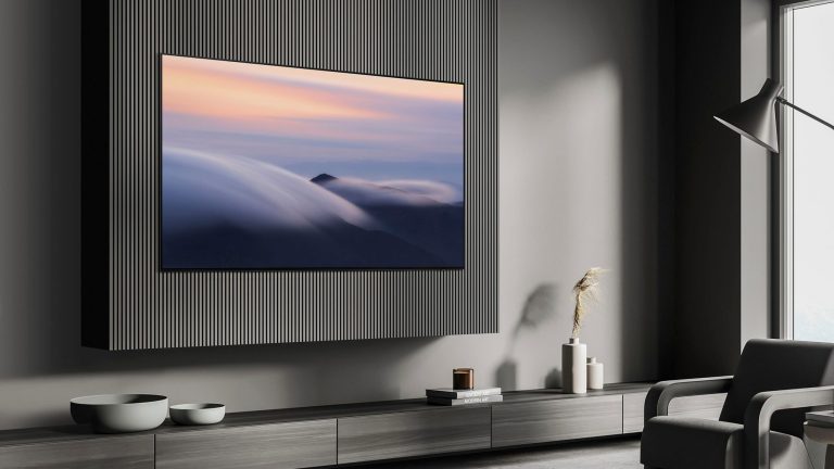 Ein Samsung S90 hängt an einer verkleideten Wand über einer TV-Bank in einem modernen Wohnzimmer.)