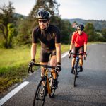 Zwei Personen erklimmen eine Stra&szlig;e mit leichter Steigung auf ihren Rennr&auml;dern.