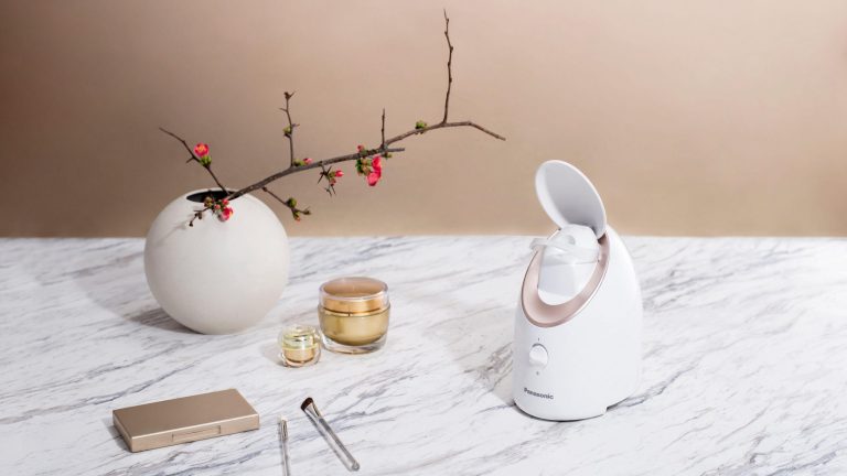Home Spa, Diese Gadgets sorgen für Wellness zu Hause Die Panasonic Gesichtssauna steht auf einem Tisch neben Kosmetikprodukten.