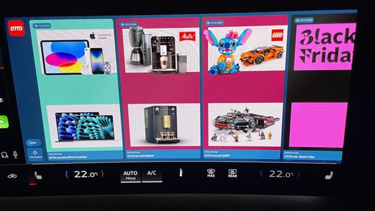 Erlebe OTTO Live Shopping im Audi Q6 e-tron! Eine Nahaufnahme eines integrierten Displays in einem Auto. Darauf sind verschiedene Angebote des OTTO Shops zu sehen.