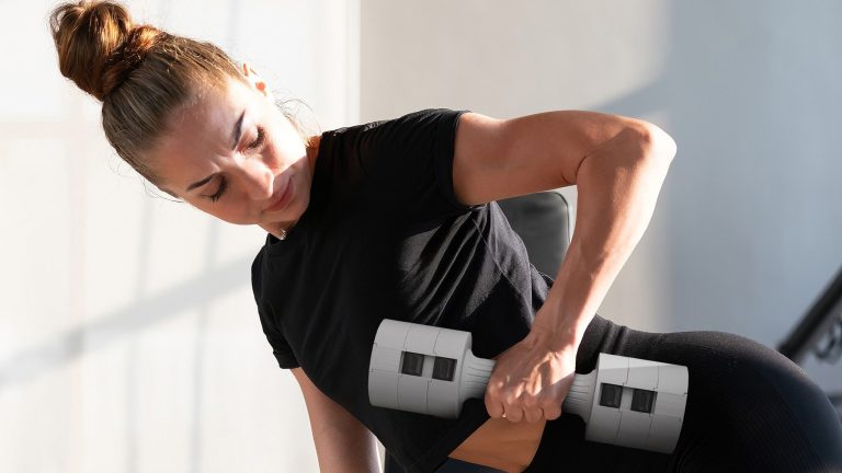 Mehr Fitness, So klappt's 2025 Eine Person beugt sich nach vorn und hebt eine stylische Kurzhantel mit einer Hand an.