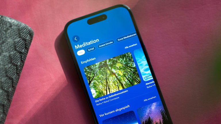 KI App, Mach dir deinen Alltag einfach mit diesen Apps Ein iPhone mit einer geöffneten Meditations-App, liegt auf einer Yogamatte.