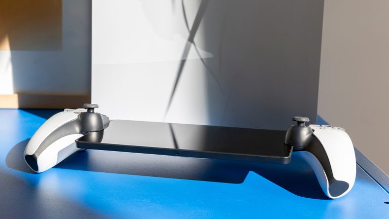 PlayStation Portal, Wie gut das PS-Streaming klappt Ein PlayStation Portal liegt auf einem blauen Regal vor einer PS5.