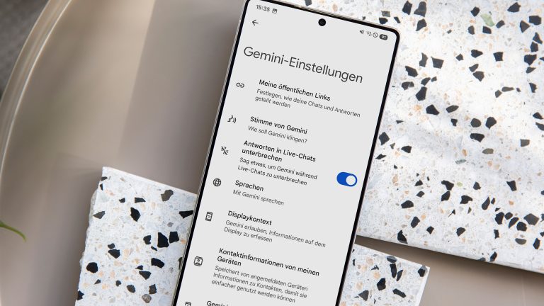 Samsung Galaxy S25, So nutzt du die Gemini-Integration Ein Samsung Galaxy S25 Ultra liegt auf einem teilweise marmorierten Untergrund. Auf dem Screen sind die Gemini-Einstellungen in den Systemeinstellungen zu sehen.