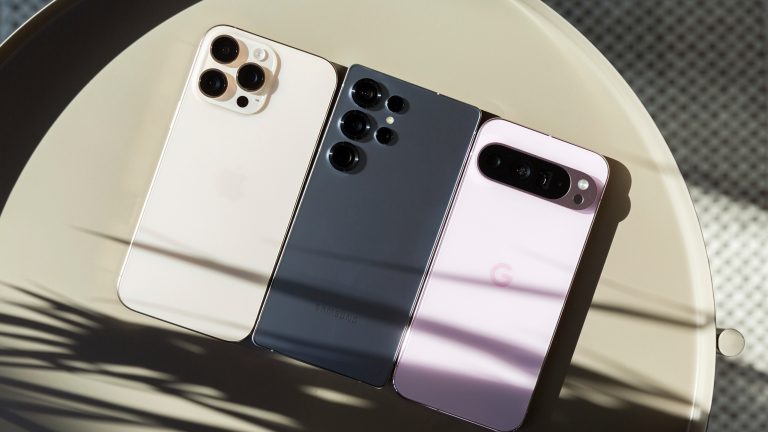 iPhone 16 Pro Max vs. Galaxy S25 Ultra vs. Google Pixel 9 Pro XL, Premium-Smartphones im Vergleich Ein iPhone 16 Pro Max, ein Galaxy S25 Ultra und ein Pixel 9 Pro XL liegen nebeneinander auf einem Tisch.