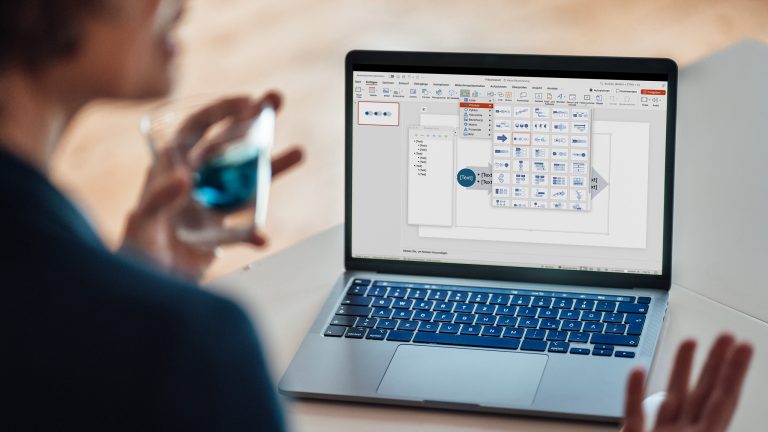 Zeitstrahl in PowerPoint einfügen und bearbeiten, Schritt für Schritt Rückansicht einer Person, die vor einem geöffneten Laptop sitzt. Das Menü zur Erstellung eines individuellen Zeitstrahls in PowerPoint ist geöffnet.