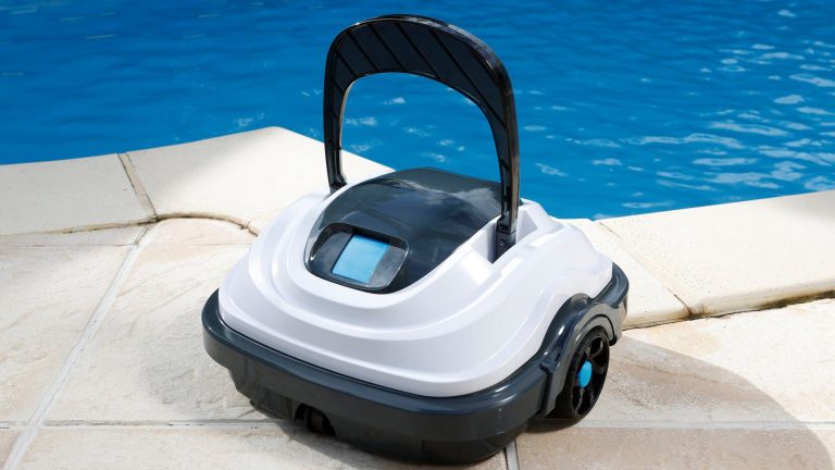 Gartenarbeit leicht gemacht, Mit diesen smarten Gartengeräten klappt's Ein Poolroboter steht auf hellen Bodenfliesen am Rand eines Pools.