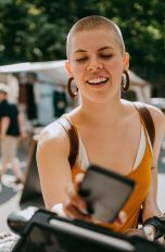 Eine Person steht mit ihrem Handy vor einem Stand und bezahlt per Google Pay.