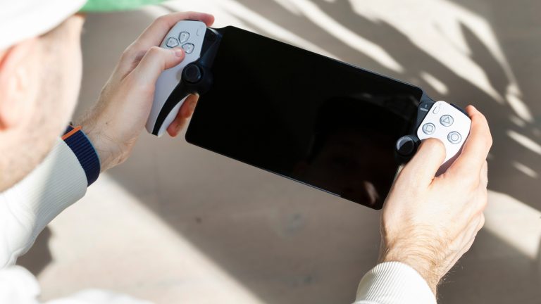 Eine Person hält ein PS Portal in der Hand, dessen Display schwarz ist.