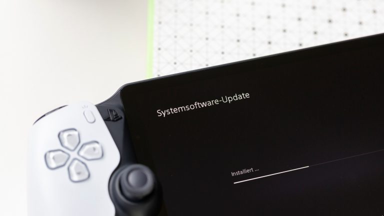 PS Portal verbindet sich nicht, So löst du das Problem Ein PS Portal liegt auf einer Oberfläche. Auf dem Display ist die Durchführung eines Updates zu sehen.