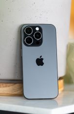 iPhone 15 Pro & Pro Max, Noch immer sehr interessant Ein iPhone 15 Pro lehnt an einem Blumentopf.