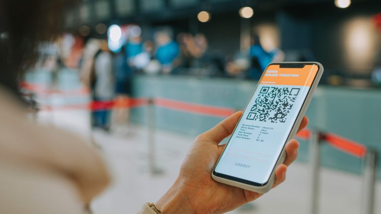 QR-Code erstellen, Mit diesen Apps und Services klappt es Eine Person hält ein Smartphone in der Hand, auf dem ein QR-Code zu sehen ist.