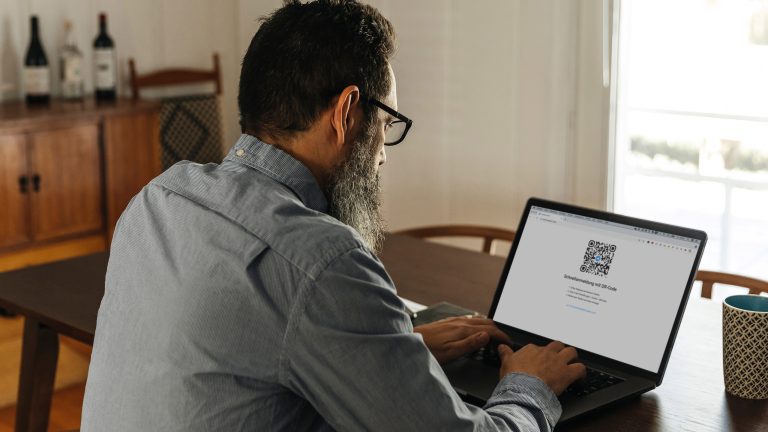 Eine Person sitzt vor einem Laptop und meldet sich bei Telegram Web an.