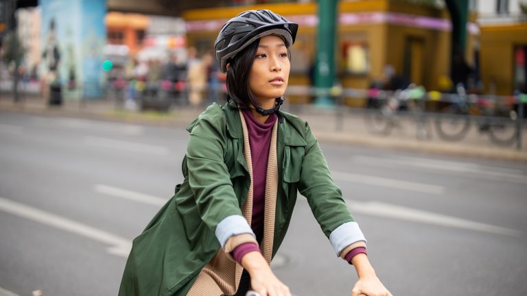 Smarte Helme, Was du darüber wissen musst Eine Person auf einem Fahrrad in der Stadt trägt einen Helm.