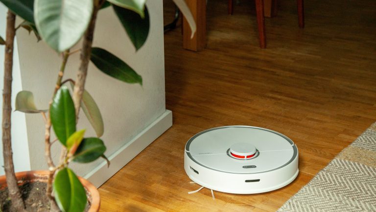 Ein Saugroboter f&auml;hrt &uuml;ber einen Holzboden.