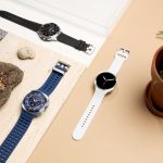Die Galaxy Watch8, Watch8 Classic und Watch Ultra liegen auf hellen Flächen neben einem Stein und einer Pflanze.