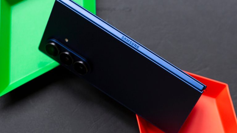 Galaxy-Fold7-80 Blick auf ein Samsung Galaxy Z Fold7 von der Seite, währen das Gerät teilweise aufgeklappt auf bunten Schalen steht.
